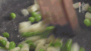 鍋中油7成熱時，入青豆、筍丁翻炒，然后加糯米飯加鹽均勻翻炒。