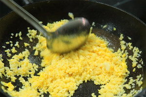 大火加熱炒鍋，再入油，燒到四至五成熱時倒入雞蛋液，在未凝結(jié)之前，加米飯煸炒，不停翻炒并用鍋鏟將成塊的米飯碾開、撥散。