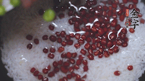 將炒好的食材和大米、紅豆一起放進(jìn)電飯鍋煮。