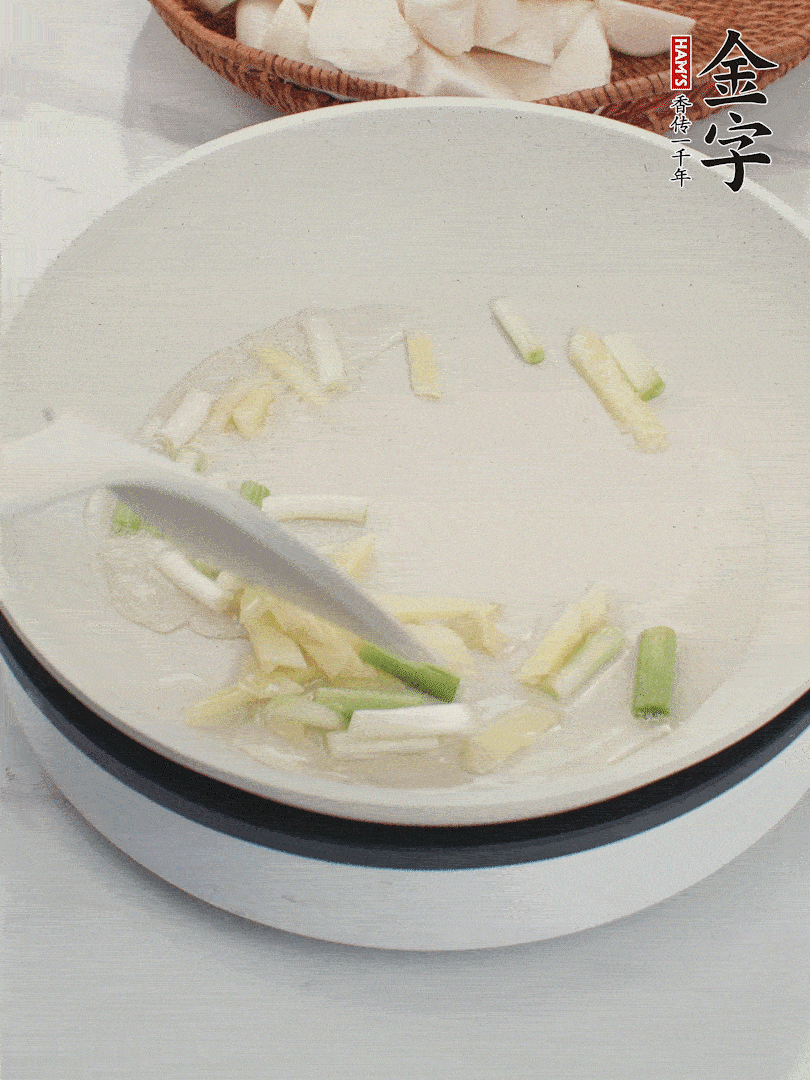 鍋中油五成熱，下蔥白、姜片爆香。