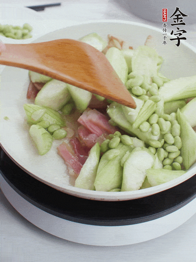 依次下絲瓜、青豆翻炒，炒至絲瓜打蔫縮小。