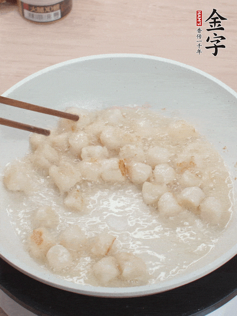 油溫4成熱，鮮貝蘸干淀粉下鍋煎，一面微黃后翻面。