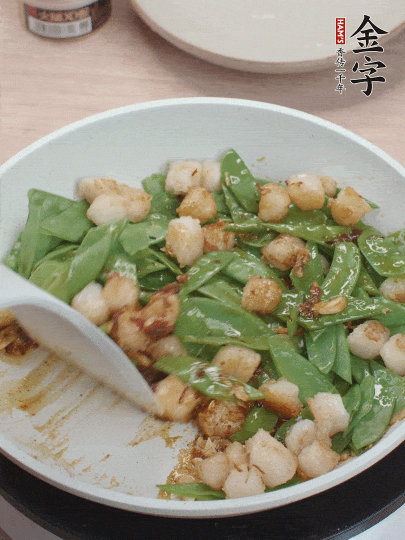 下甜豆莢、鮮貝輕輕翻炒均勻。