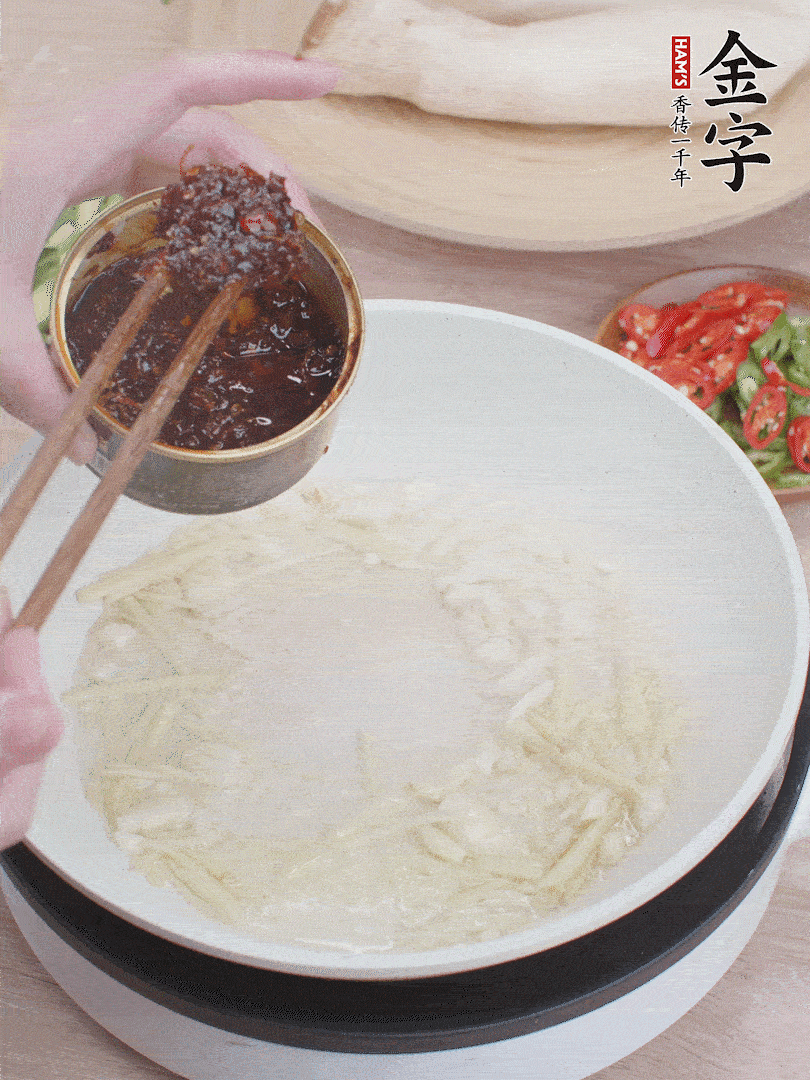 起鍋熱油，姜蒜、金字火腿干貝醬煸香。