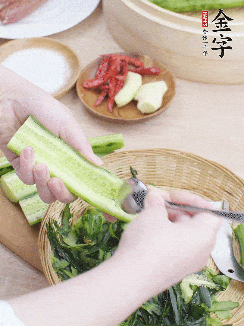 黃瓜削皮，對(duì)半切開，勺子挖去內(nèi)瓤，斜刀切片。青蒜斜刀切段。