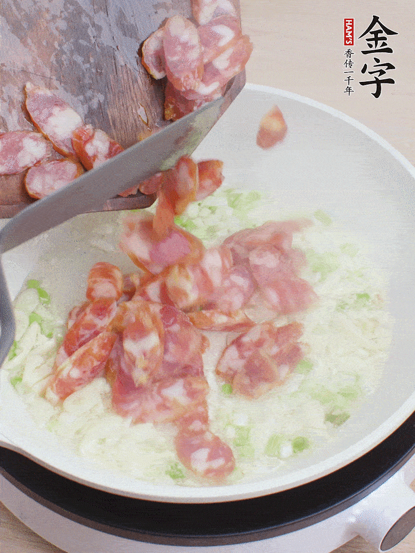 油5成熱，蒜末、蔥白爆香，下香腸炒出香味。