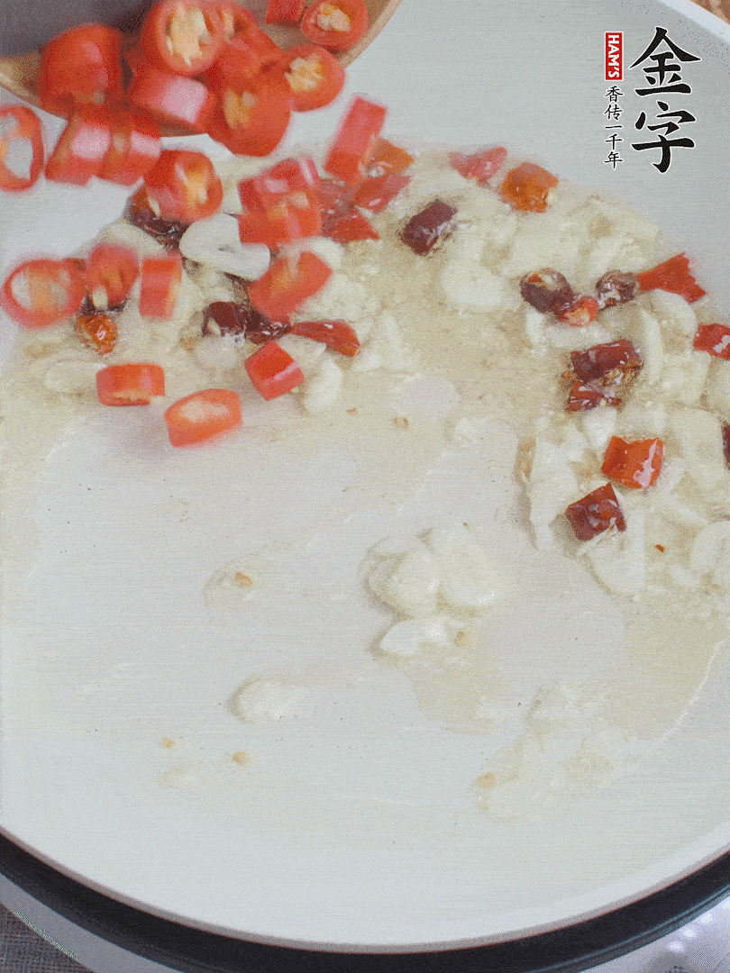 油6成熱，下蒜末、干紅辣椒煸炒，出香味后再放美人椒、香腸。