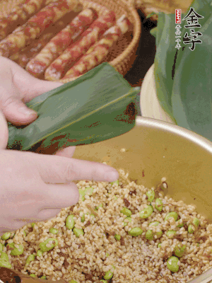 粽葉往下折，完全蓋住，兩側(cè)捏緊。