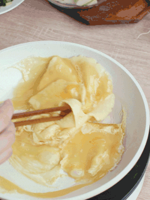 油6成熱時(shí)，下雞蛋液，邊緣凝固時(shí)翻拌成塊狀。