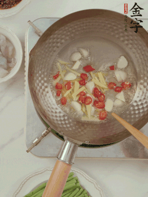 油7成熱時(shí)，下大蒜粒、姜絲、小米辣煸香。