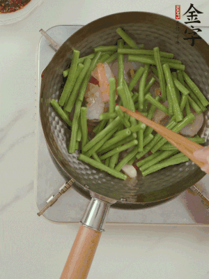 下掰好的缸豆段翻炒，略燜煮。
