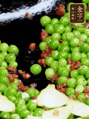 鍋內(nèi)少許油，下火腿煸香，再下甜豆米、百合翻炒，少許鹽、一點水煮到收干