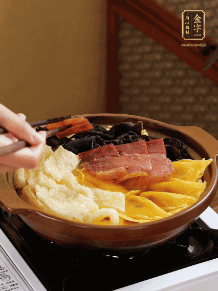 砂鍋底部鋪上娃娃菜，依次擺上肉皮、蛋餃、黑木耳、火腿