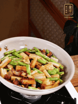 油熱下蒜末、干辣椒、醬肉煸炒出香味，依次下藕條、豆角翻炒均勻